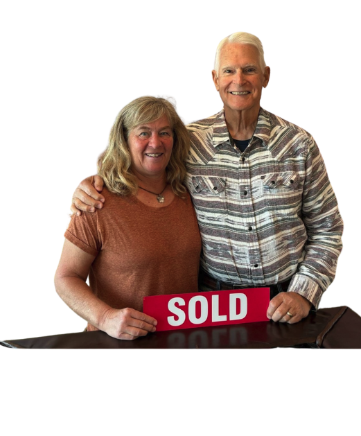 Tracy and John R. holding a SOLD sign after closing with Sheila Chonis